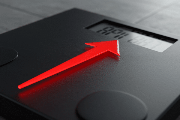 Weight gain indicator on scale symbolizing the health impact of irregular night shift eating habits.