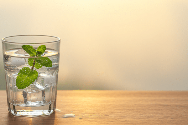 Refreshing glass of water with mint, encouraging night shift workers to support hydration for better appetite control.