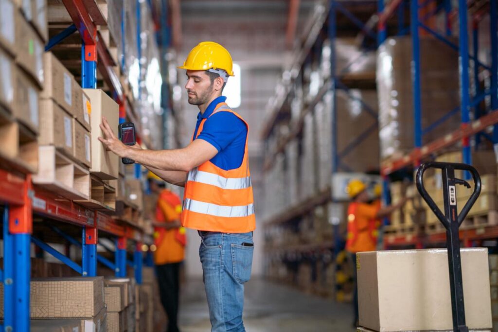 Warehouse worker scanning packages during overnight third shift.